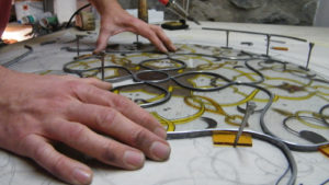 Diego Tolomelli in Iko studio e la tessitura a piombo di una vetrata artistica dipinta a grisaglia e smalti